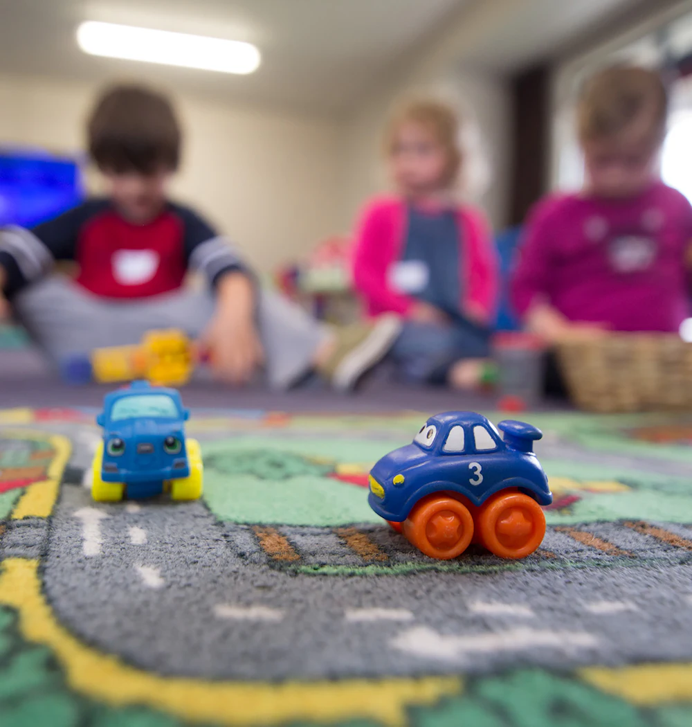 Young children playing with toys on a classroom floor